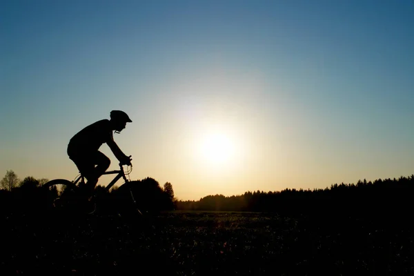 Gün Batımında Bisiklet Süren Bir Adamın Silueti — Stok fotoğraf