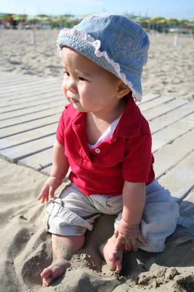 ビーチに座っている帽子の少女 — ストック写真