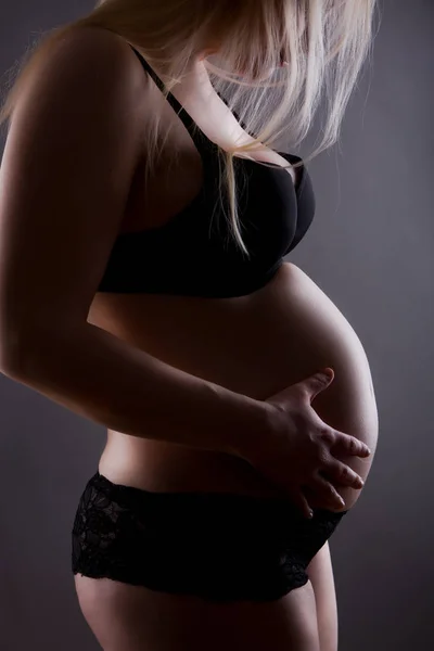 白い背景に黒いランジェリー姿の妊婦が — ストック写真