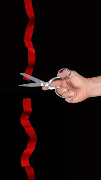 scissors and red ribbon on black background