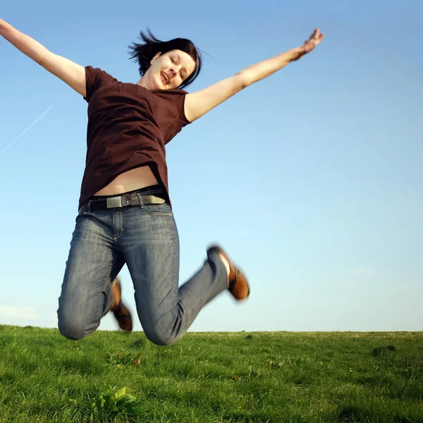 Young Woman Jumping Field Stock Image