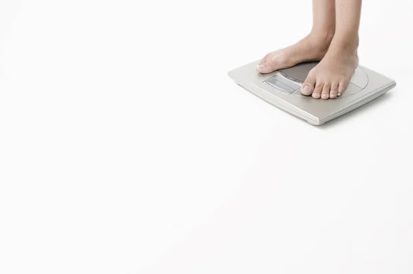 白い背景にタブレットPcを搭載した女性の足は — ストック写真