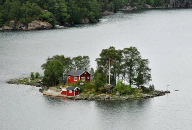 small cottage in a fjord in norway. clipart