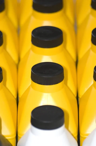黑色底座上的黄色塑料瓶 — 图库照片