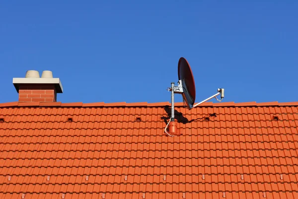 ソーラーパネル付きの家の屋根の上の衛星料理 — ストック写真