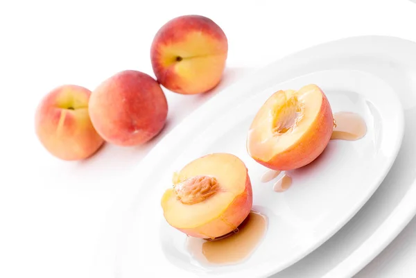白い皿にシロップをかけた新鮮な桃 — ストック写真
