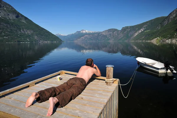 Человек Лежащий Сопле Озером — стоковое фото
