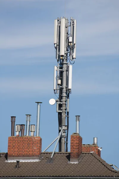 テレビの屋根の上に携帯電話の電波塔とアンテナがある通信アンテナ — ストック写真