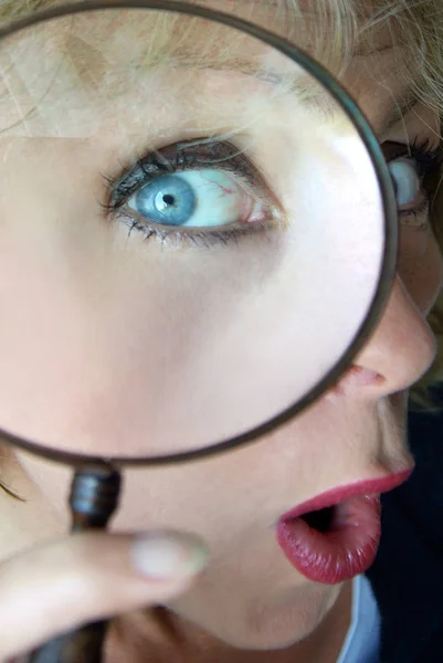 close-up of a woman\'s eye with a magnifying glass