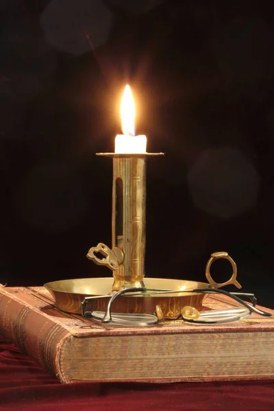 木桌上有蜡烛和墨水瓶的旧书 — 图库照片
