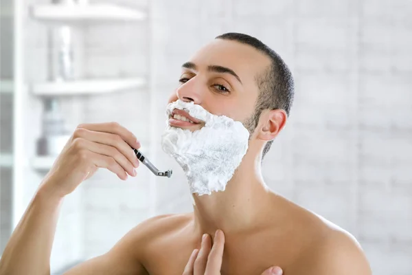 バスルームで髭を剃るハンサムな男 — ストック写真