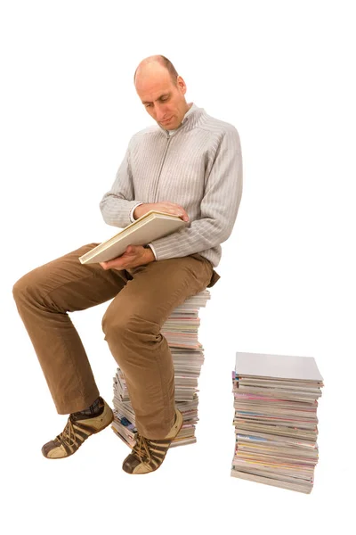 Homme Est Assis Sur Une Pile Magazines Regarde Livre — Photo