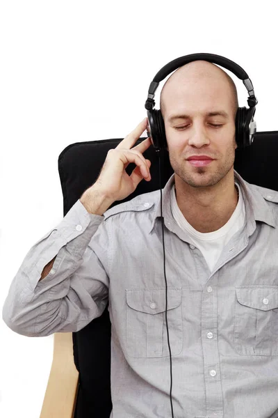 Jovem Sentado Ouvindo Música Isolado Branco — Fotografia de Stock