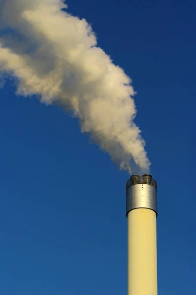 青い空に煙と工業用煙突 — ストック写真