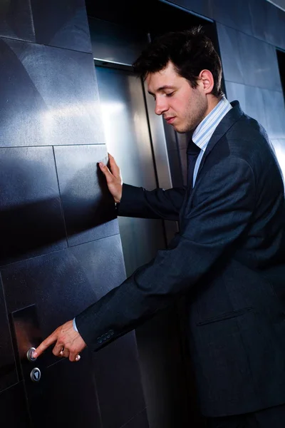 엘리베이터를 부르는 잘생긴 사업가의 — 스톡 사진