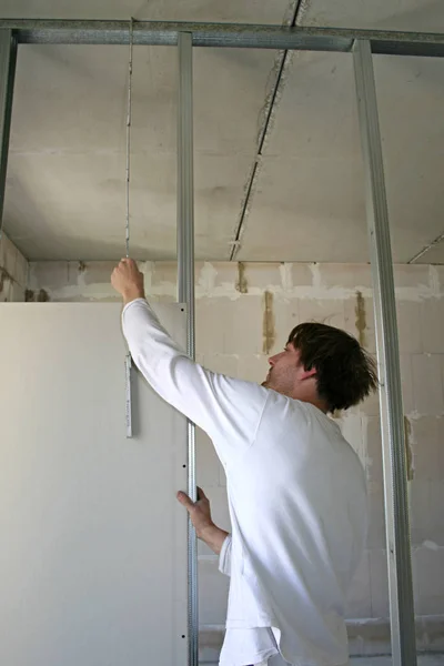 man in a white shirt painting a wall