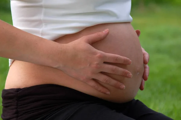お腹の妊娠中の手 — ストック写真