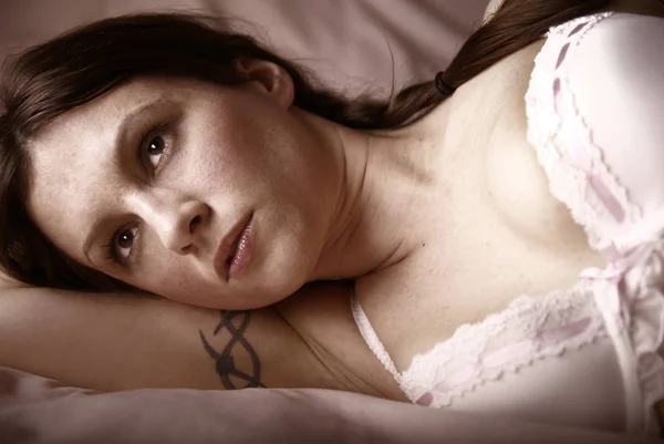 ベッドの上に横たわるランジェリー姿のセクシー女性 — ストック写真