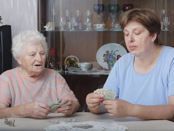 senior woman with money in the kitchen