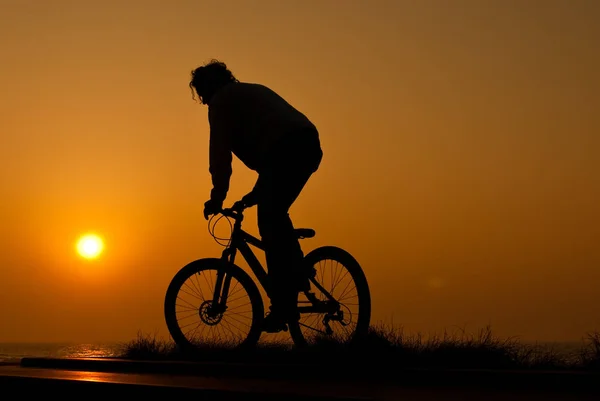 骑自行车的年轻成年人的轮廓 — 图库照片