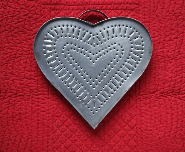 punched tin heart on quilt