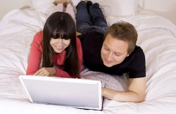 Young Couple Lying Bed Home Using Laptop Computer Stock Picture