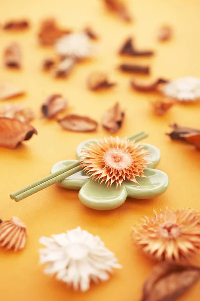お香がオレンジ色のテーブルに乾いた花を貼る — ストック写真