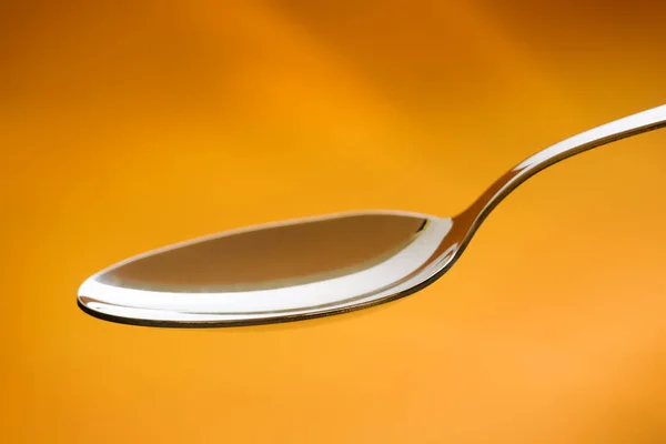 Cucchiaio Metallo Vuoto Uno Sfondo Arancione — Foto Stock
