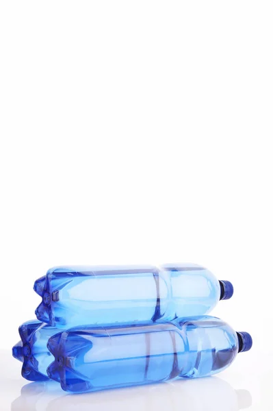 Изолированные Синие Бутылки Водой Белом Отражающем Фоне — стоковое фото