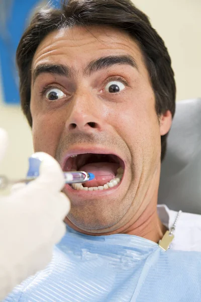 Dentysta Trzymający Strzykawkę Znieczulający Swojego Przerażonego Pacjenta — Zdjęcie stockowe