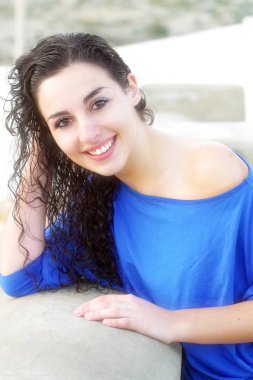 A portrait of a woman with wet curly hair wearing a blue top. clipart