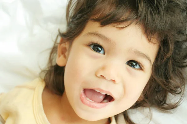침대에 누워서 미소짓고 아름다운 아이입니다 아시아인 파란만장 — 스톡 사진