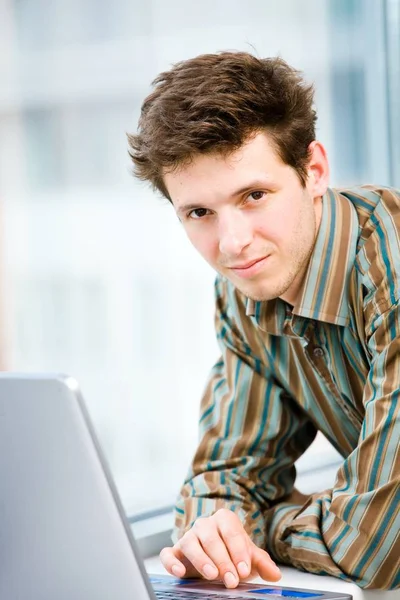 Lässig Aussehender Glücklicher Geschäftsmann Der Vor Dem Bürofenster Laptop Arbeitet — Stockfoto