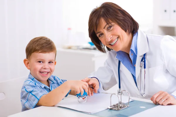 Starsza Pediatra Bawiąca Się Dzieckiem Gabinecie Lekarskim — Zdjęcie stockowe