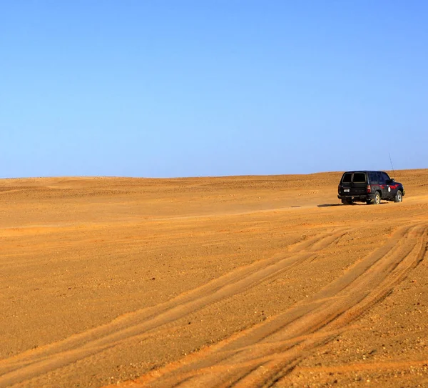 砂漠の風景の中をジープが走り — ストック写真
