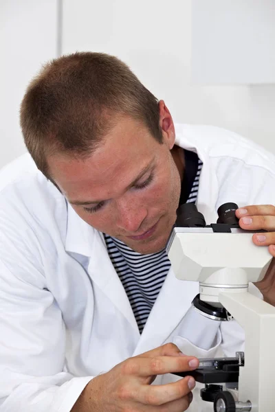 Jovem Técnico Laboratório Ajusta Microscópio — Fotografia de Stock