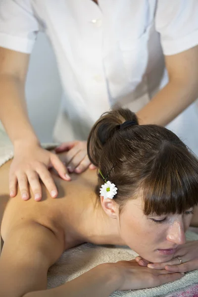 young woman receiving back massage in spa