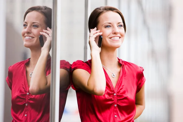 Woman Leaning Reflective Building Her Cell Phone — Stock Photo, Image