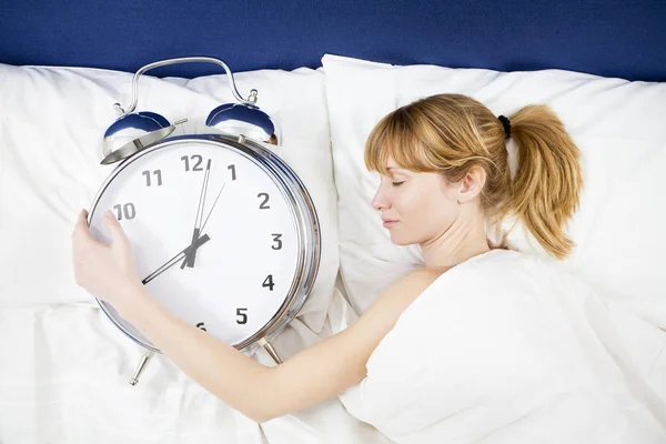Young Woman Lying Bed Eyes Closed Holding Huge Alarm Clock — Stock Photo, Image