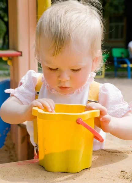 Маленька Дівчинка Виглядає Жовтому Відрі Піском Пісочниці Дитячому Майданчику — стокове фото