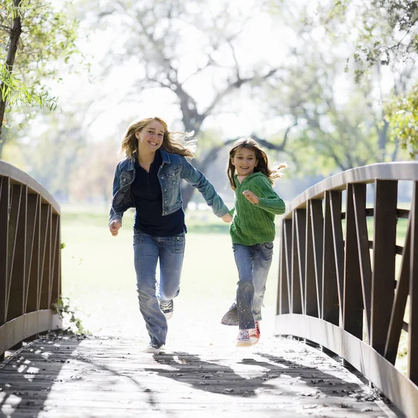 Dos Chicas Corriendo Través Puente Parque — Foto de Stock