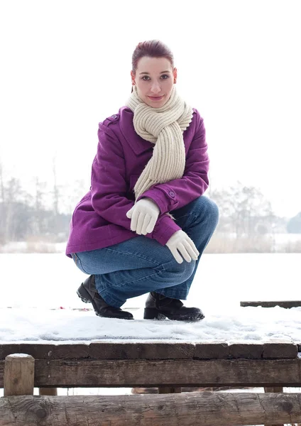 Kışlık Elbiseli Genç Bir Kadın Bankta Oturuyor — Stok fotoğraf
