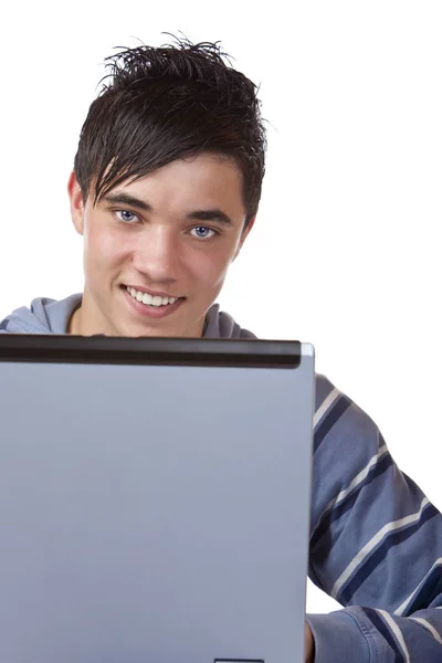 在家里的电脑笔记本电脑上工作的年轻英俊少年 — 图库照片