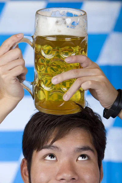 man having Oktoberfest beer stein on head