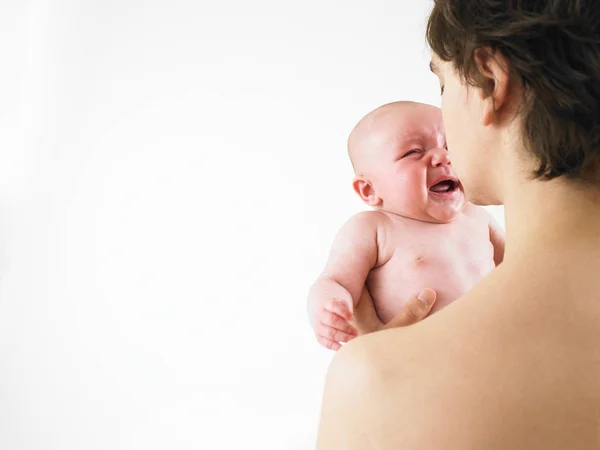 泣いている赤ん坊を抱えている親の切り取られた眺め 横枠のショット — ストック写真