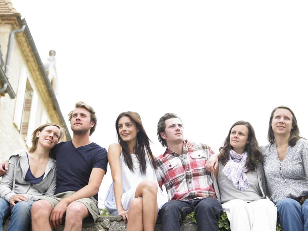 Grupo Jóvenes Sentados Juntos Aire Libre Mirando Distancia Horizontal — Foto de Stock