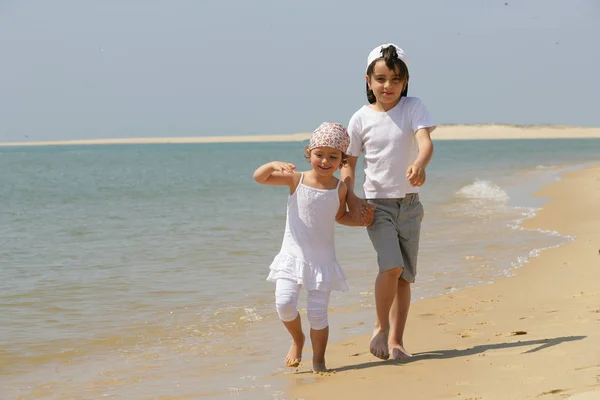 Boy and girl walking along the sea holding hands