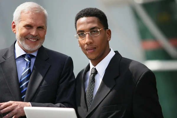 Portrait of men in suits in front of a laptop