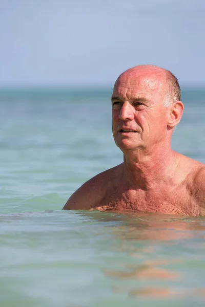 Yaşlı Adam Ayaklarının Dibinde Palmiye Dalışıyla Denizde Yıkanıyor — Stok fotoğraf