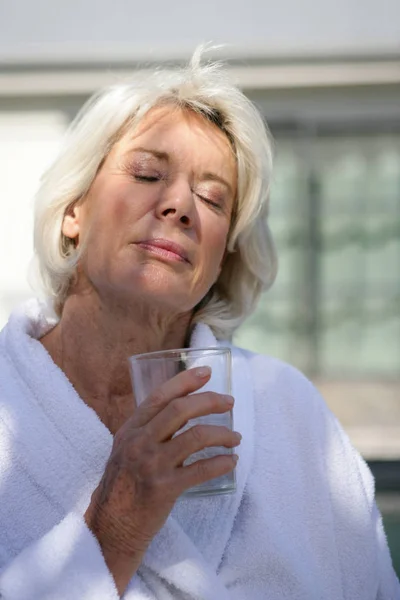 Porträt Einer Seniorin Bademantel Die Mit Einem Glas Wasser Die — Stockfoto